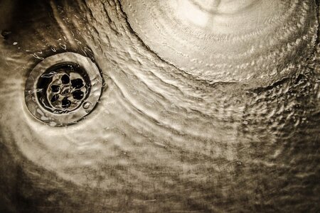 Wasser läuft in einem Edelstahl-Spülbecken in den Abfluss.